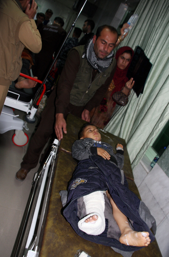 12일 규모 7.3의 강진이 덮친 이라크 술라이마니야 주의 한 병원에서 부상을 입은 한 아이를 시민들이 돌보고 있다.     /술라이마니야=AFP연합뉴스