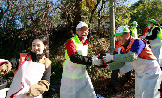 최신원 회장은 다양한 봉사활동에 직접 참여하고 있다. 연탄 배달 봉사에 나선 최신원 회장(왼쪽 두 번째)이 활짝 웃고 있다