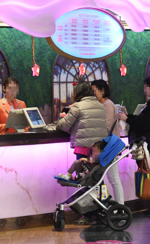 10일 서울 송파구 롯데월드 매표소 앞에서 아이와 함께 놀이공원을 찾은 부모가 티케팅을 하고 있다. /송은석기자