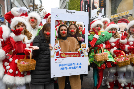 13일 서울 명동에서 열린 ‘에버랜드, 도심에서 미리 만나는 크리스마스’ 공연에서 한 일본 관광객이 에버랜드 대표 캐릭터 등과 사진을 찍고 있다. 에버랜드는 오는 18일부터 12월 말까지 44일간 겨울축제 ‘크리스마스 판타지’를 연다.  /송은석기자