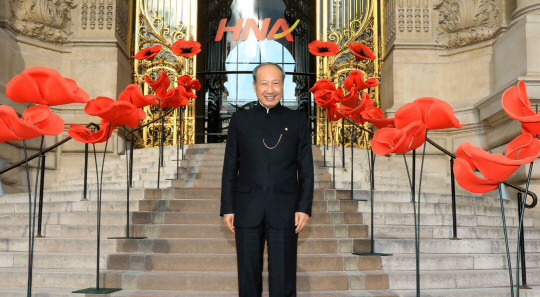불교 신자 사업가 : HNA 창업주 천 펑이 파리의 프티 팔레 박물관을 배경으로 활짝 웃고 있다. HNA는 지난 6월 이곳에서 천의 64번째 생일을 축하하기 위한 자선행사를 개최했다. 독실한 불교신자인 그는 “매일 행하는 명상이 HNA의 성장을 이끈 중요한 원동력”이라고 말했다.