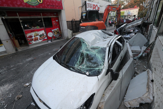 경북 포항시 북구 흥해읍 한 마트 외벽이 지진 영향으로 일부 무너져 차량 위로 떨어져 내렸다./연합뉴스