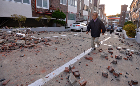 15일 오후 2시 29분쯤 포항에 발생한 진도 5.4 규모의 지진으로 북구 환호동 한 빌라 외벽이 지진으로 인해 무너진 가운데 한 시민이 대피하고 있다./사진=매일신문 제공