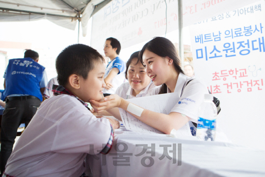효성 미소원정대에 참가한 직원이 베트남 롱토지역 어린이를 진료하고 있다. / 사진제공=효성