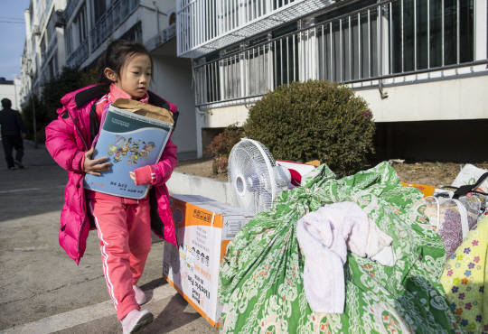 포항 지진으로 붕괴 위험이 있는 포항시 북구의 한 아파트에서 어린이가 부모를 도와 짐을 옮기고 있다. /포항=장지승기자