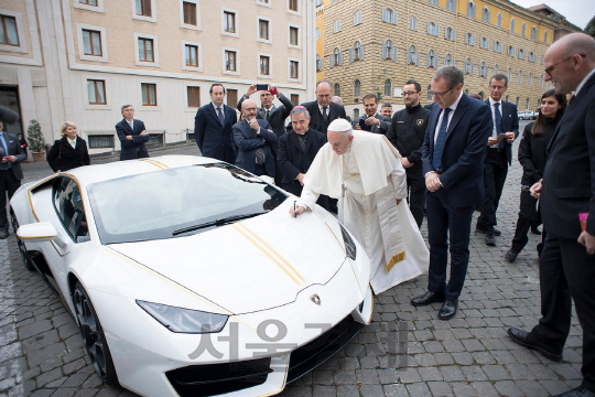 프란치스코 교황이 람보르기니가 교황을 위해 단 한대만 생산한 우라칸 RWD 스페셜 에디션 차량에 기념 사인을 하고 있다./사진제공=오토모빌리 람보르기니