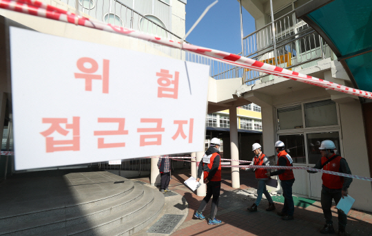 포항 흥해초등학교에서 대한건축학회 조사단이 지진 피해를 본 학교건물을 살펴보고 있다.  /연합뉴스