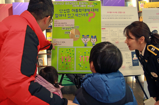 지난 19일 서울 종로구 교보문고 광화문점에서 서울 종로경찰서와 초록우산 어린이재단이 진행한 아동학대 근절 캠페인에 한 가족이 참여하고 있다 /사진제공=종로경찰서