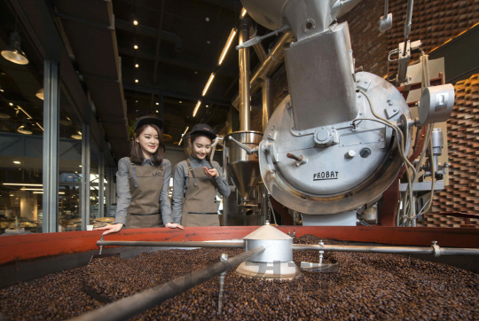 이디야커피랩의 바리스타들이 커피 원두가 기계로 로스팅(볶음)되는 과정이 잘 이뤄지고 있는지 살피고 있다. /사진제공=이디야커피