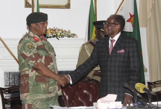쿠데타를 주도한  콘스탄티노 치웬가 장군과 악수하는 로버트 무가베 짐바브웨 대통령/AP연합뉴스