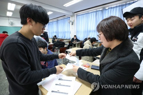 24일 오전 서울 여의도고에서 2018학년도 대학수학능력시험을 응시한 학생들이 선생님과 가채점 결과를 확인하고 있다./연합뉴스