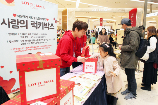 26일 롯데몰 수원점을 방문한 고객들이 ‘사랑의 럭키박스’ 추첨을 하고 있다. 롯데몰 수원은 기부금 2,000원을 모금함에 넣으면 무작위로 럭키박스를 증정하는 이 행사를 통해 기부금 전액을 수원 지역 내 도움이 필요한 기관에 전달할 예정이다./사진제공=롯데자산개발