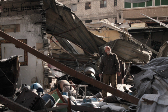 시리아 수도 다마스쿠스 동쪽 외곽인 구타 지역의 주민이 26일(현지시간) 정부군의 습격으로 무너져 내린 건물을 살펴보고 있다. /구타=AFP연합뉴스