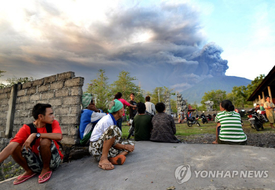 <YONHAP PHOTO-1446> Balinese people look at Mount Agung during an eruption seen from Kubu sub-district in Karangasem Regency on Indonesia‘s resort island of Bali on November 26, 2017. Mount Agung belched smoke as high as 1,500 metres above its summit, sparking an exodus from settlements near the mountain. / AFP PHOTO / SONNY TUMBELAKA/2017-11-26 09:00:06/<저작권자 ⓒ 1980-2017 ㈜연합뉴스. 무단 전재 재배포 금지.>