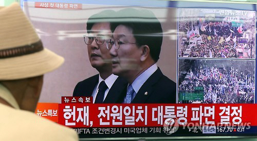 3월 10일 대전역 대합실에 모인 시민들이 박근혜 대통령 탄핵 인용 소식을 전하는 뉴스 보도를 바라보고 있다. /연합뉴스