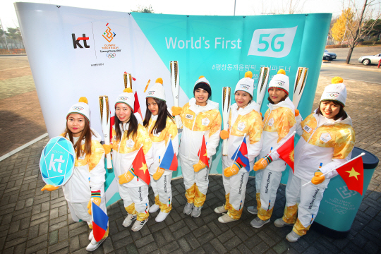 다문화 여성들이 KT 성화봉송 주자로 달리기 전 출신 국가의 국기를 들고 기념 촬영을 하고 있다./사진제공=KT