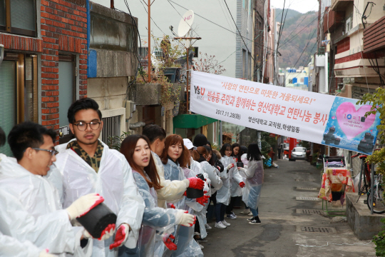 28일 와이즈유 학생들과 교직원이 해운대구 반송에서 연탄 나눔봉사를 하고 있다./사진제공=와이즈유 영산대학교