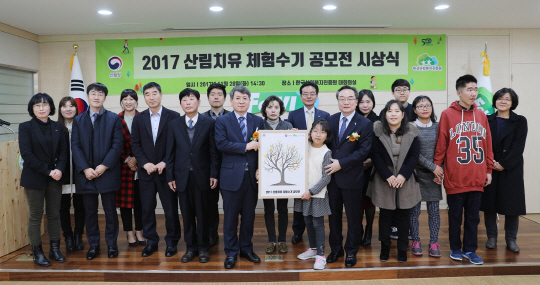 류광수(사진 앞줄 왼쪽에서 다섯번째) 산림청 차장과 윤영균(〃여덟번째) 한국산림복지진흥원장이 ‘2017 산림치유 체험수기 공모전’ 시상식후 수상자들과 기념촬영을 하고 있다. 사진제공=산림청