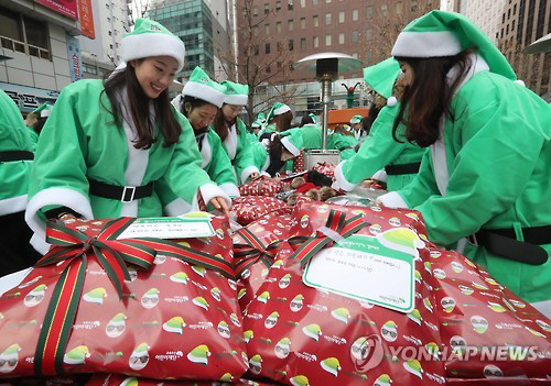 지난해 12월 초록우산어린이재단 앞 광장에서 열린 ‘복면 산타’ 캠페인 행사장에서 자원봉사자들이 선물을 포장하고 있다. /연합뉴스