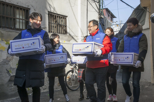 삼성전자 임직원들이 6일 서울 동대문 쪽방촌에서 쪽방에 거주하는 어르신들에게 전달할 생필품 세트를 나르고 있다./사진제공=삼성전자