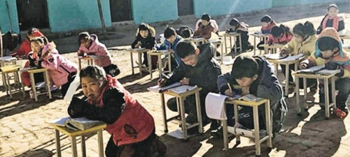 ‘가스대란’을 겪고 있는 중국에서 초등학교 교실이 너무 추워 학생들이 볕이 있는 운동장에서 공부를 하는 사태까지 벌어졌다./출처= 홍콩 명보 캡처