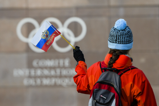 6일 IOC 본부 밖에서 한 여성이 러시아 국기를 흔들고 있다. 평창올림픽에서는 러시아 국기를 볼 수 없다. /로잔=AP연합뉴스