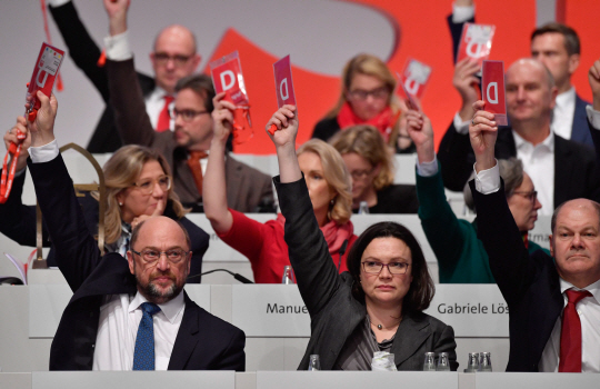 마르틴 슐츠(앞줄 왼쪽) 독일 사회민주당(SPD) 대표가 7일(현지시간) 베를린에서 열린 전당대회에서 대의원들과 앙겔라 메르켈 총리가 이끄는 기독민주·기독사회당 연합과의 대연정 협상 개시에 대해 투표하고 있다. /베를린=AFP연합뉴스