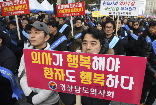 10일 오후 서울 중구 덕수궁 대한문 앞에서 열린 ‘문재인 케어 반대 및 한의사의료기기 사용 반대 전국 의사 총궐기대회’에서 참석자들이 피켓을 들고 구호를 외치고 있다./송은석기자songthomas@sedaily.com