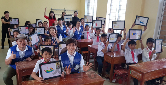 삼성물산 봉사단원들이 지난 7일 베트남 끼안시사 하하이 중학교를 방문해 학생들과 그림 수업을 진행하고 있다./사진제공=삼성물산