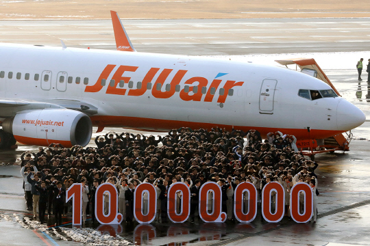 제주항공 임직원 200여명이 18일 김포국제공항에서 항공기를 배경으로 숫자 ‘10,000,000’을 나타내는 조형물을 들고 ‘연간 승객 1000만명 돌파’를 자축하고 있다. /사진제공=제주항공