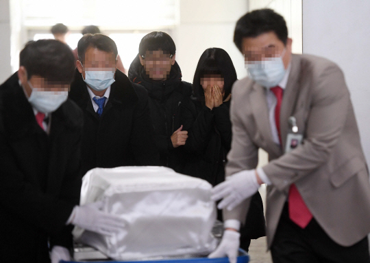 19일 서울시 양천구 이대목동병원 장례식장에서 진행된 신생아 발인에서 유가족들이 운구차로 옮겨지는 관을 바라보며 눈물을 흘리고 있다.          /권욱기자