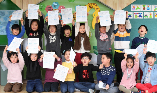 22일 서울 용산구 용암초등학교에서 겨울방학을 맞은 1학년 학생들이 방학생활계획표를 들고 환하게 웃고 있다.     /권욱기자