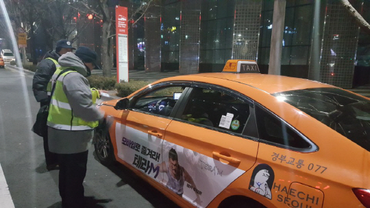 1서울시 승차거부 단속반원들이 15일 밤 강남역 사거리에서 택시표시등을 꺼놓고 대로 변에 주차한 채 영업행위를 하던 택시차량을 적발해 과태료를 부과하고 있다. /박진용기자