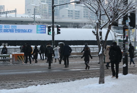 지난 21일 출근하는 고양 시민들이 보도의 눈을 뒤로하고 횡단보도를 건너고 있다./연합뉴스