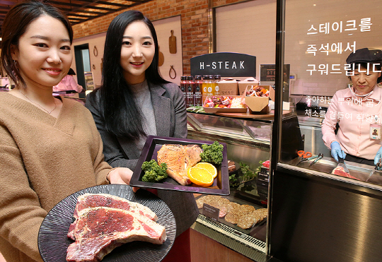 현대백화점 직원들이 25일 서울 강동구 천호점 식품관에서 구매한 고기를 굽기를 원하는 고객들에게 현장에서 바로 구워주는 ‘H스테이크’ 코너를 소개하고 있다. /사진제공=현대백화점