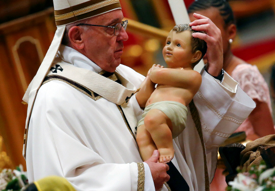 프란치스코 교황이 24일(현지시간) 바티칸 성 베드로 성당에서 성탄 전야 미사를 집전하며 아기 예수상을 안고 있다.    /바티칸=로이터연합뉴스