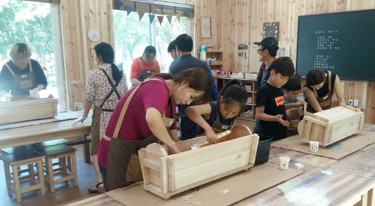 경기숲 시흥 나눔목공소에서 목공지도사들이 부모와 함께 찾아온 어린이들을 대상으로 목공 체험 프로그램을 운영하고 있다. /사진제공=경기도