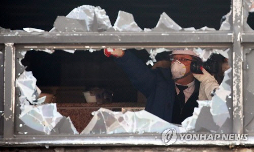 깨진 유리창을 둘러보고 있는 소방합동조사단의 모습 /연합뉴스