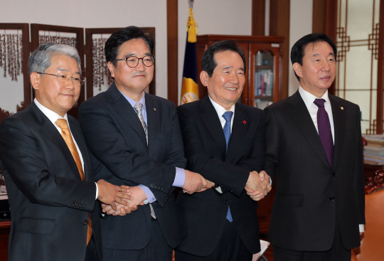 29일 오전 국회 본청 의장실에서 정세균 국회의장과 3당 원내대표들이 현안처리를 위한 국회 본회의 개최 및 민생법안 처리 합의문을 발표한 뒤 손을 맞잡고 있다. 왼쪽부터 김동철 국민의당 원내대표, 우원식 더불어민주당 원내대표, 정세균 국회의장, 김성태 자유한국당 원내대표. /연합뉴스