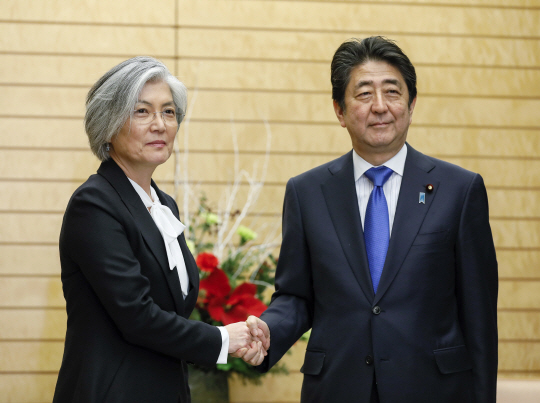 강경화(왼쪽) 외교부 장관이 지난 19일 일본 도쿄 총리 관저에서 아베 신조 일본 총리와 악수하고 있다. /도쿄=AP연합뉴스