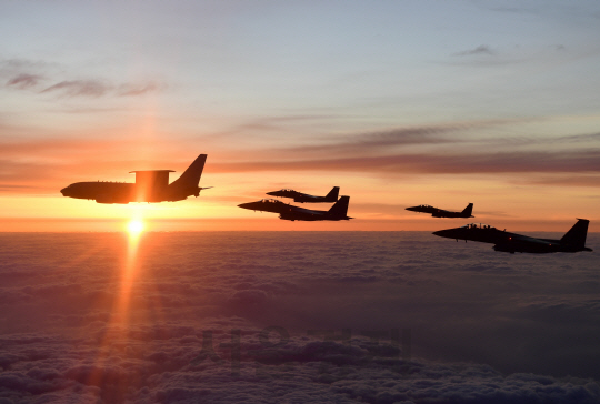 정경두 합참의장이 작전지휘비행차 탑승한 E-737 피스아이와 F-15K 호위전투기가 30일 아침 편대비행하고 있다. 동해의 떠오르는 태양이 무술년 새해의 국운 융성을 예고하는 듯 찬란하게 떠오르고 있다.