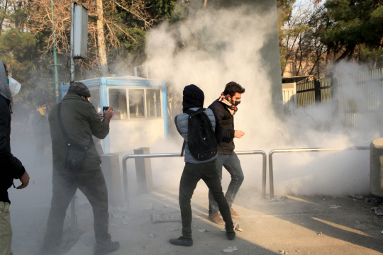 이란 테헤란대 학생들이 30일(현지시간) 최루가스가 가득한 교내에서 반정부시위를 펼치고 있다.    /테헤란=AFP연합뉴스