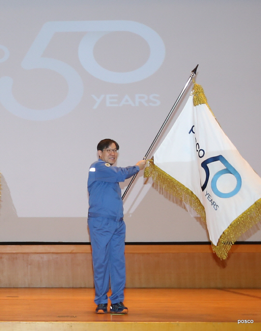 권오준 포스코 회장이 2일 포항제철소 대회의장에서 ‘2018 포스코패밀리 시무식’을 열고 ‘50주년 기념기’를 흔들고 있다./사진제공=포스코