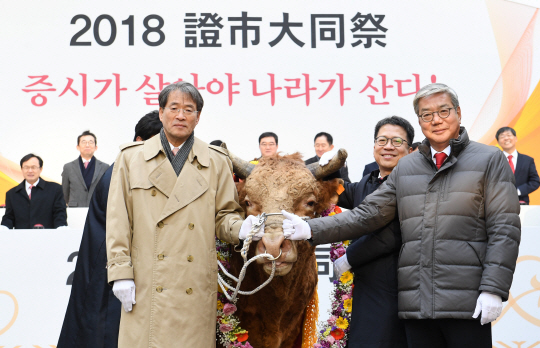 이종환(왼쪽부터) 서울경제신문 대표이사 부회장, 정지원 한국거래소 이사장, 황영기 금융투자협회장이 2일 서울 여의도 한국거래소 앞마당에서 열린 ‘2018 증시 대동제’에 참석해 증시 활황을 상징하는 황소에게 화환을 씌워준 뒤 환하게 웃고 있다./권욱기자