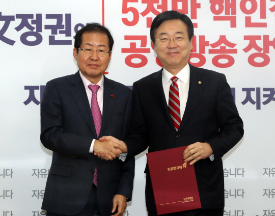 홍준표(왼쪽) 자유한국당 대표와 함께 악수하고 있는 김종석 자유한국당 의원 /연합뉴스