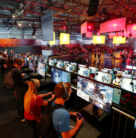 게이머들이 독일 쾰른의 무역 박람회에서 EA 제품을 시연하고 있다.