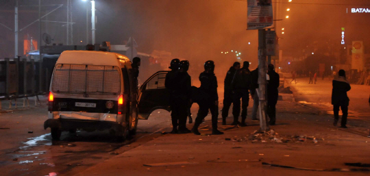 아프리카 튀니지의 수도 튀니스 인근의 에타다멘에서 경찰들이 8일(현지시간) 반정부 시위 가담자들을 추적하고 있다.          /에타다멘=AFP연합뉴스