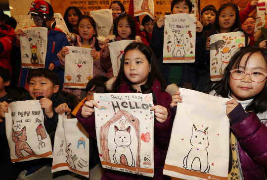 11일 서울 중구 농업박물관에서 새해맞이 ‘황금강아지 에코백 만들기’ 행사에 참가한 어린이들이 직접 만든 가방을 들어 보이며 환하게 웃고 있다.       /연합뉴스