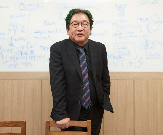 김상협 우리들의미래 이사장이 회의실에서 포즈를 취하고 있다. 녹색으로 염색한 그의 머리는 기후변화와 에너지 전환 문제에 대한 신념의 표현이다.