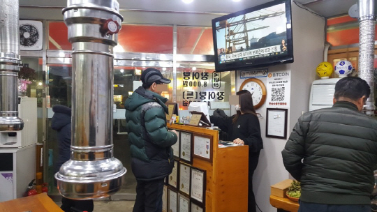 13일 서울 북가좌동의 비트코인 결제 식당에서 손님이 식사 가격을 결제하고 있다./오지현기자